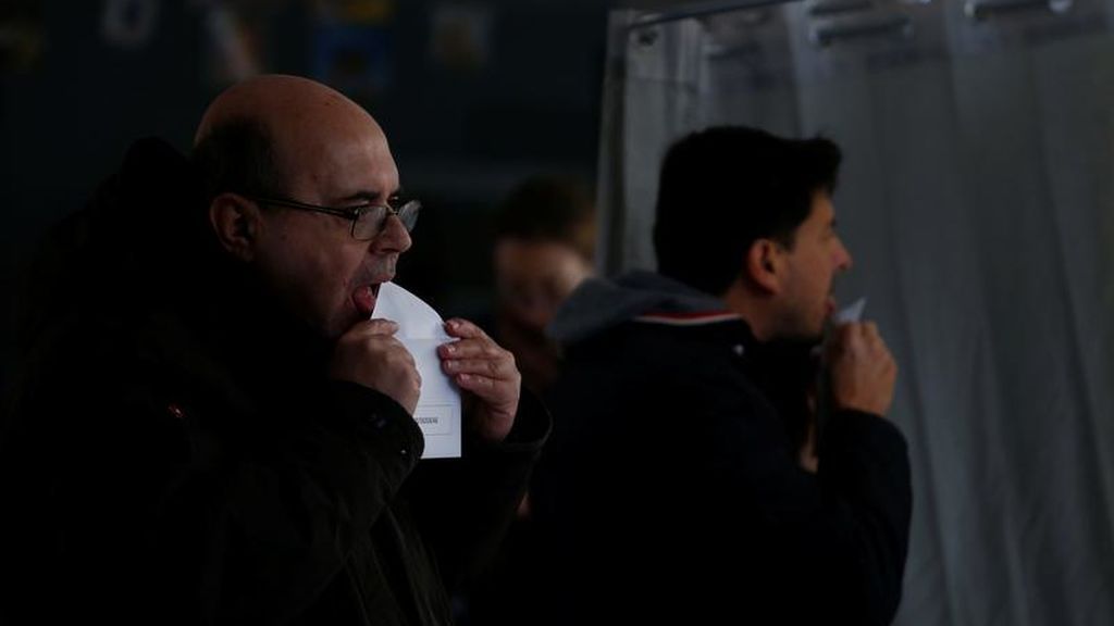 Dos hombres sellan sus sobres electorales