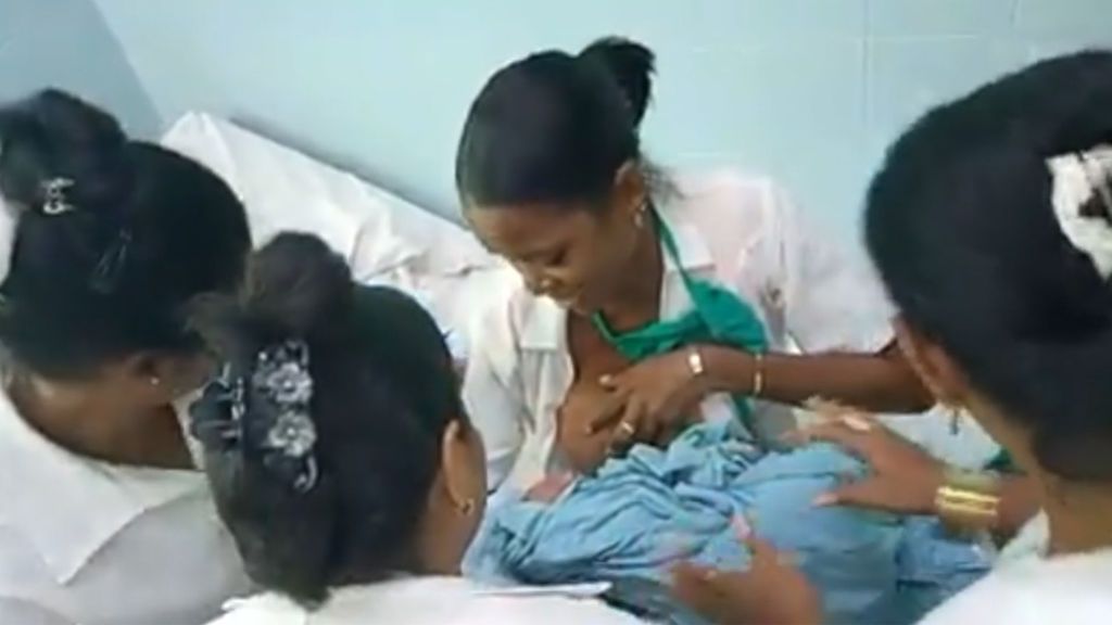 Una doctora da el pecho a una recién nacida
