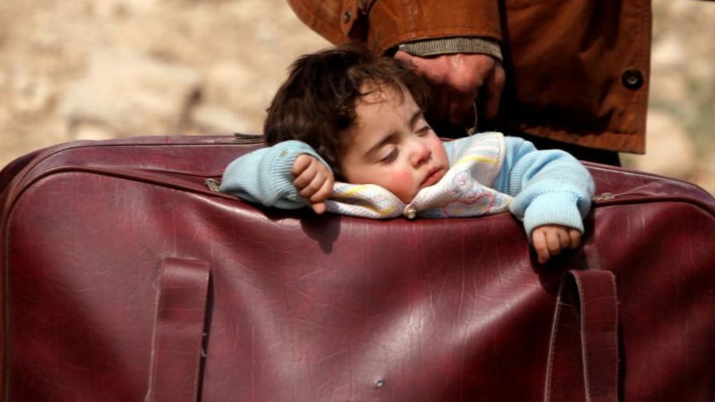 Un hombre huye de Siria llevando a su hijo en una maleta