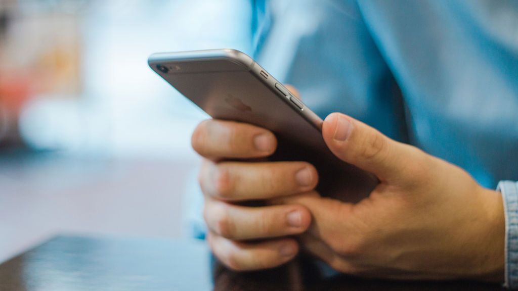 Una persona utilizando un teléfono móvil Una persona utilizando un teléfono móvil