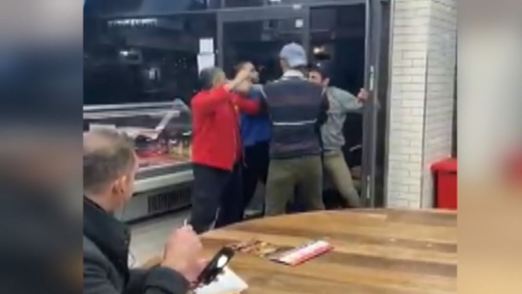 Varias personas se enfrentan en un restaurante kebab de Inglaterra mientras un hombre les observa sin inmutarse