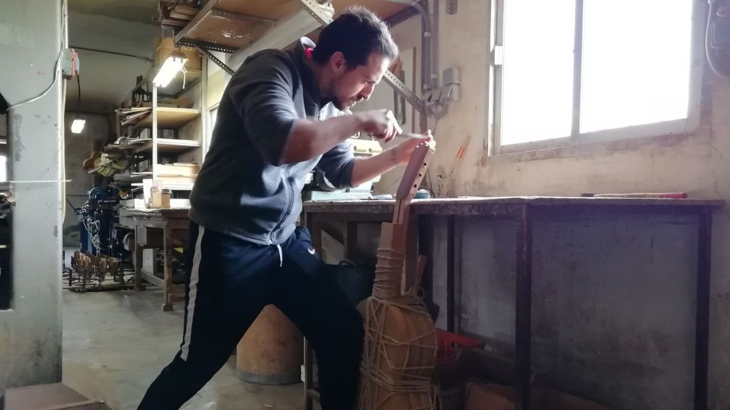 Adam Broseta lima la testa de una guitarra en el taller