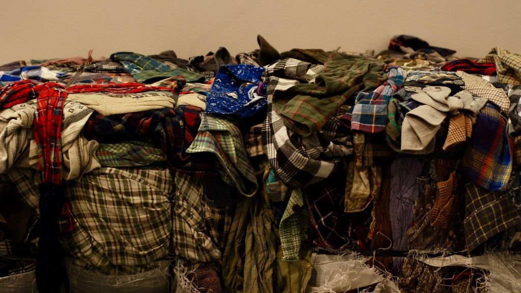 Montones de ropa reciclada en la exposición 'Fast Fashion'.