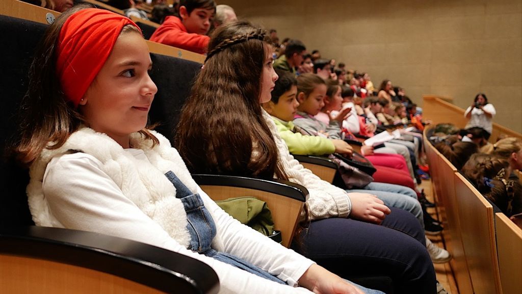 Dos niñas atienden las explicaciones de las científicas
