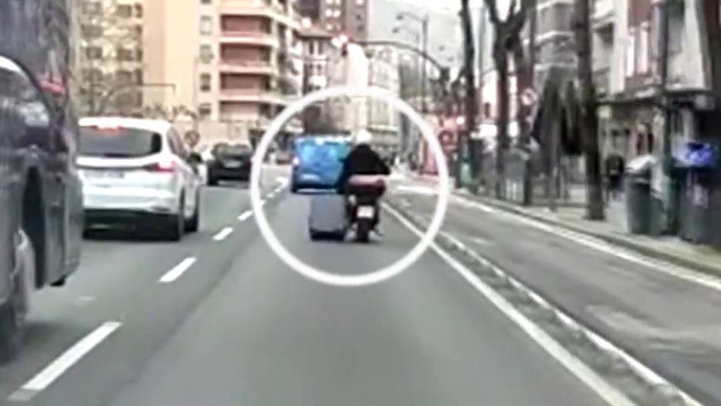 La gran imprudencia de un motorista en Bilbao al conducir arrastrando una maleta