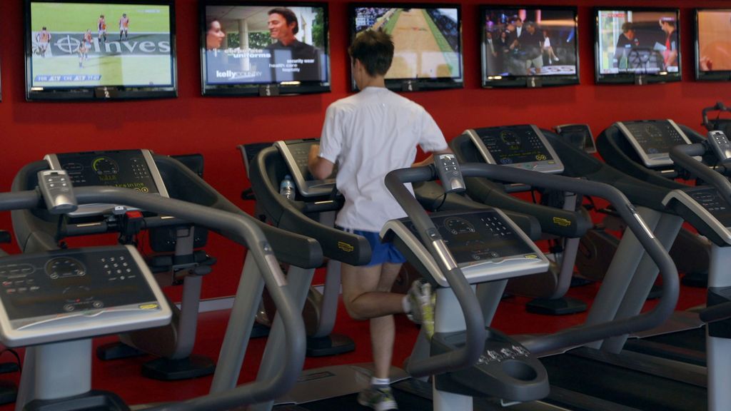 Un joven corre en un gimnasio.