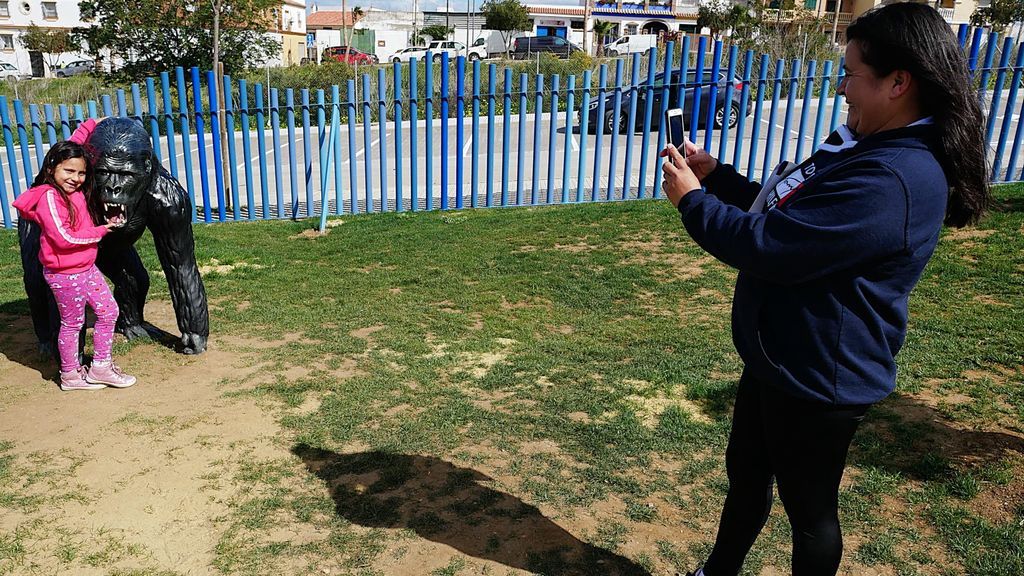 Una madre fotografía a su hija en el parque