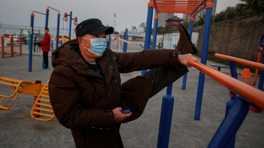 Un hombre con mascarilla realiza ejercicio físico en Jiujiang, China