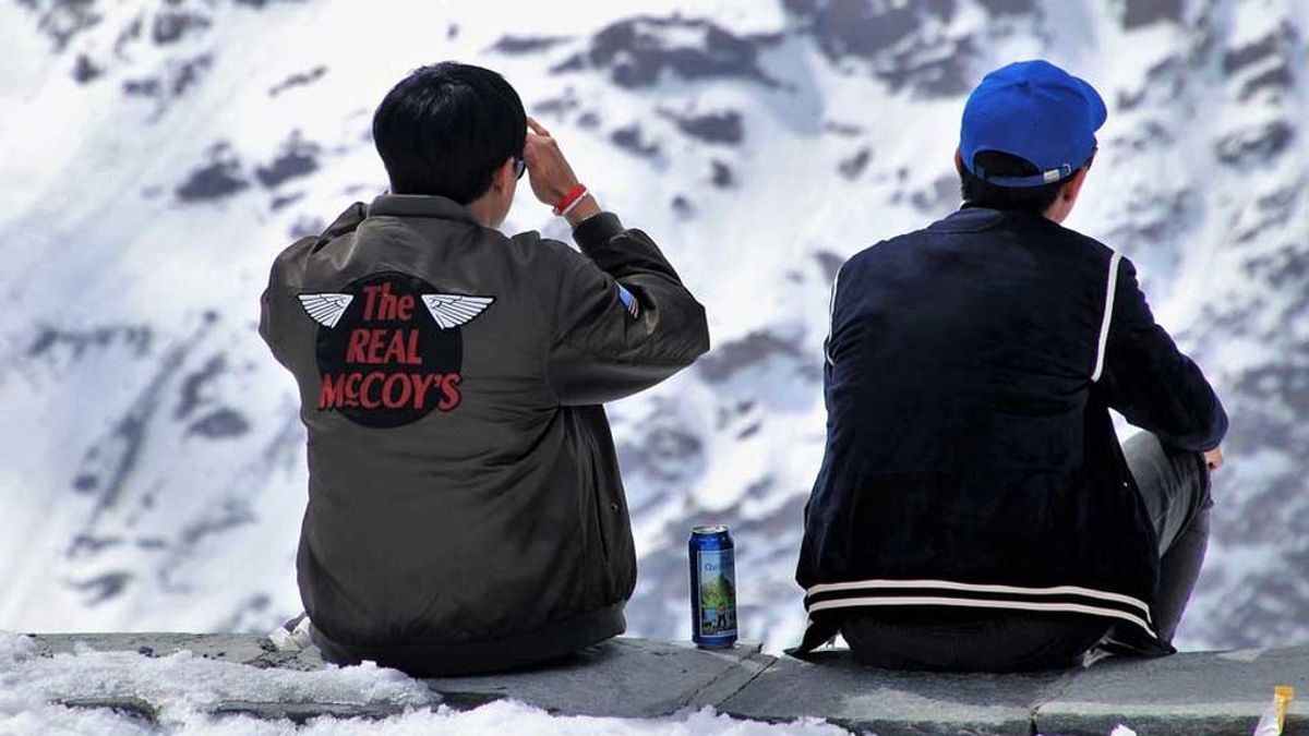 Dos turistas comparten cerveza en la nieve