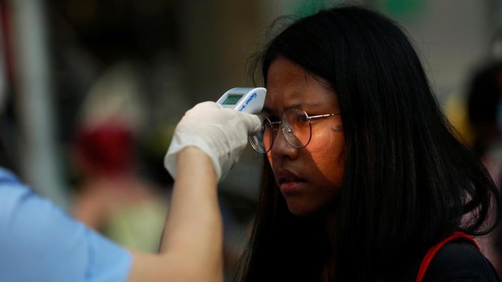 Los sanitarios toman la temperatura de una joven en China