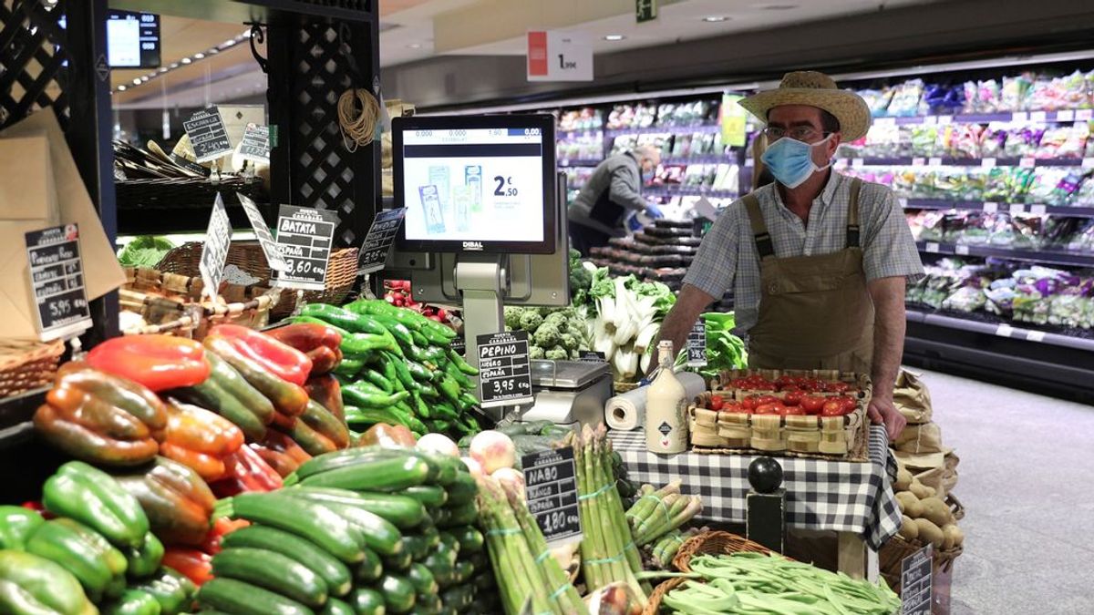 Un empleado con mascarilla y guantes en un supermercado en Madrid
