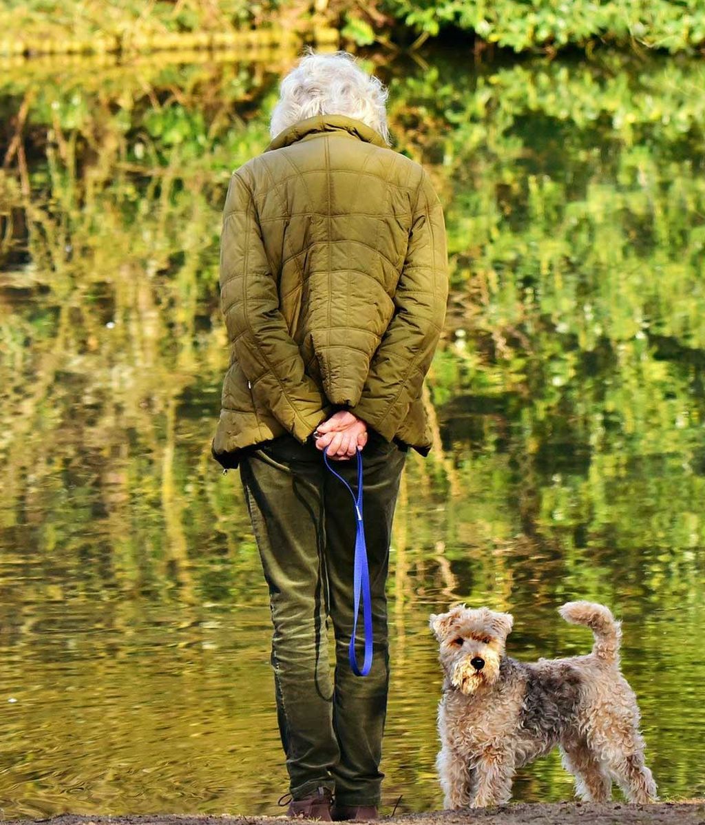 Señora mayor saca a su perro a pasear