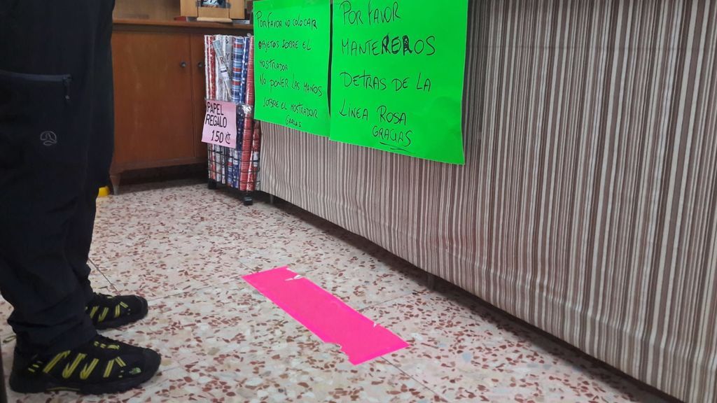 Una linea rosa marca la distancia que hay que mantener hasta el mostrador.