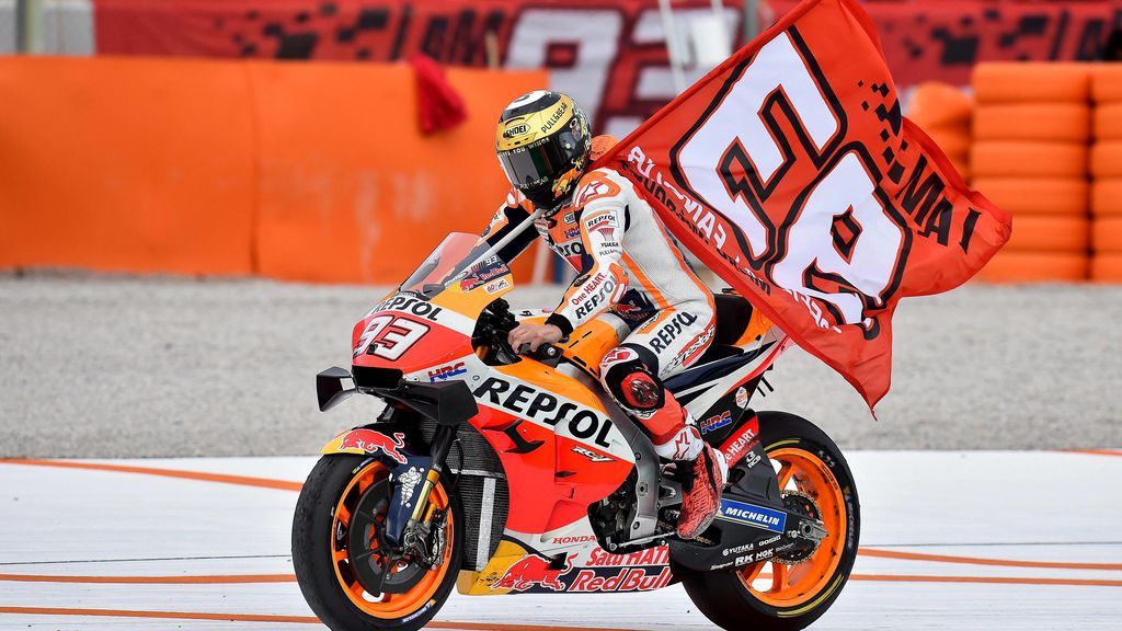 Marc Marquez celebrando una carrera llevando su bandera mientras pilota