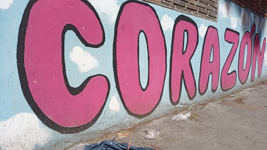 Un grafiti junto a una bolsa de basura