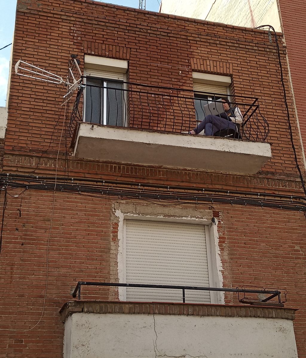 Una joven teletrabajando en la terraza