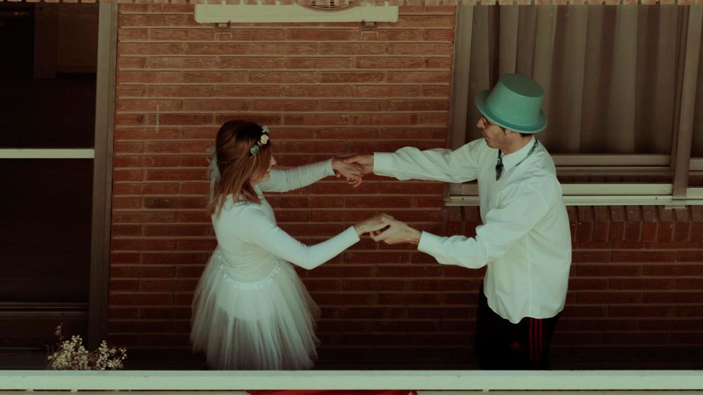 Los novios bailando el vals en el balcón de su casa.