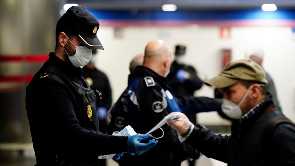 Agentes de la Policía Nacional reparten mascarillas en el transporte público