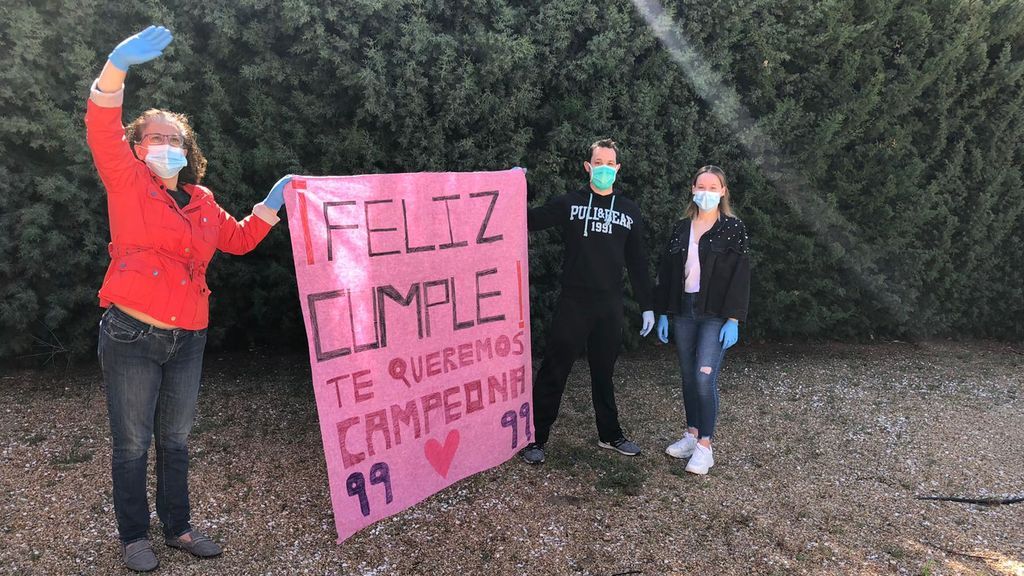 Familiares de Justina felicitándole desde el jardín de la residencia.