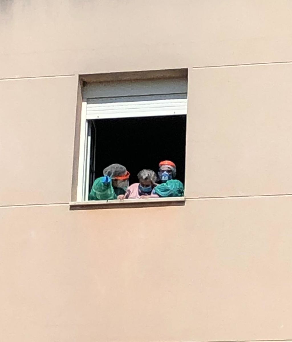Justina saludando a su familiares desde la ventana.