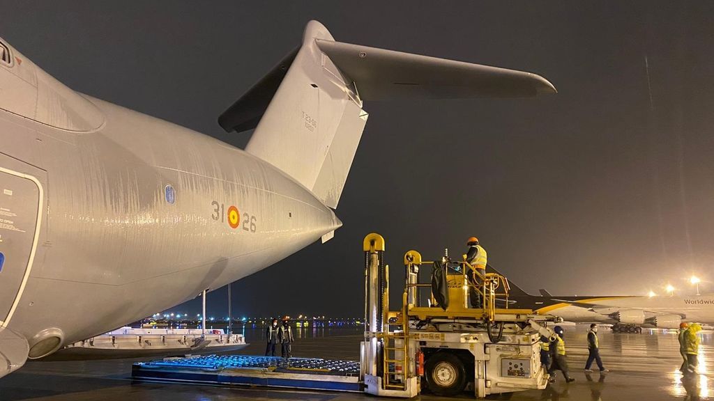 Varios trabajadores en Shangai cargan el avión del Ejército del Aire