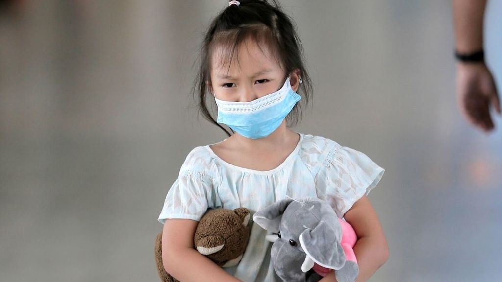 Imagen de una niña con una mascarilla de adulto