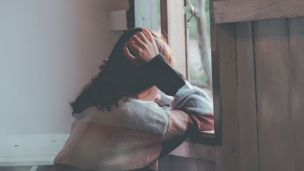 Niña asomada a ventana