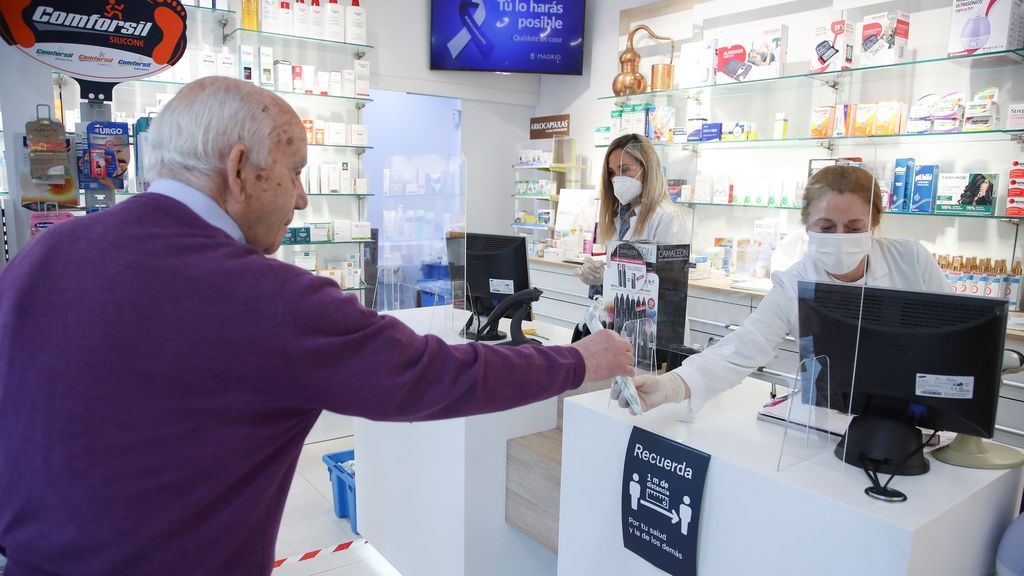 Un hombre compra en una farmacia española