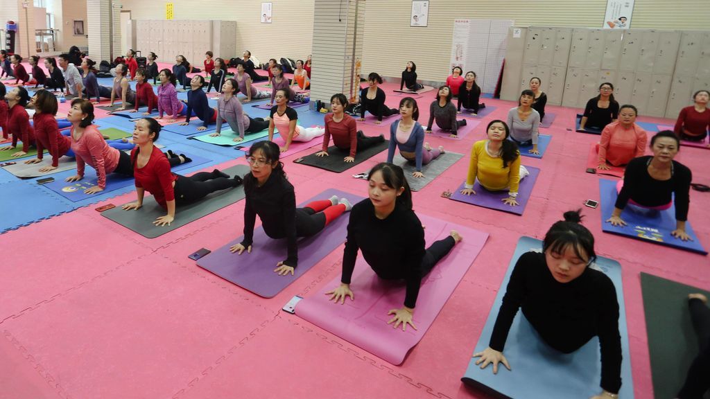 clase multitudinaria de yoga en Asia