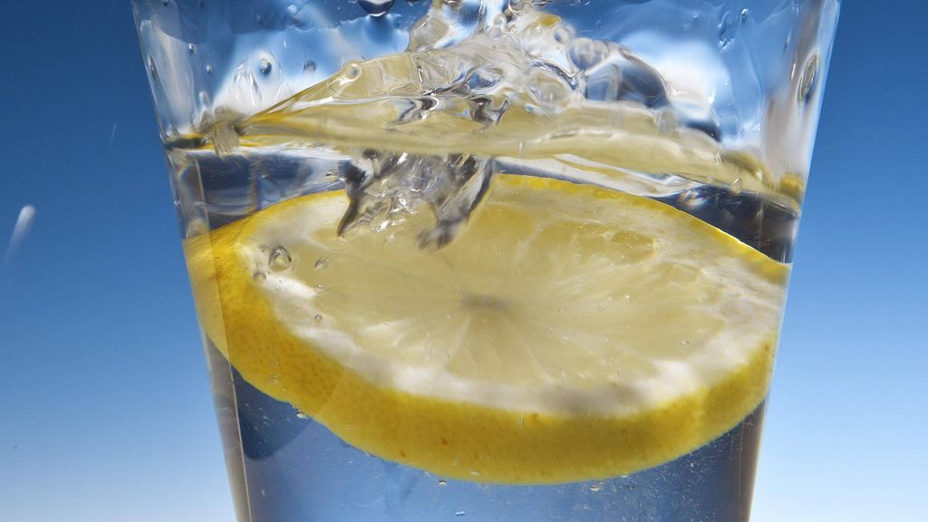 vaso con agua, limón y hielo