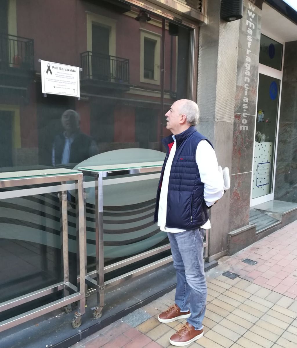 Iñaki Vallejo, mirando la esquela que ha colocado en la entrada de su local.