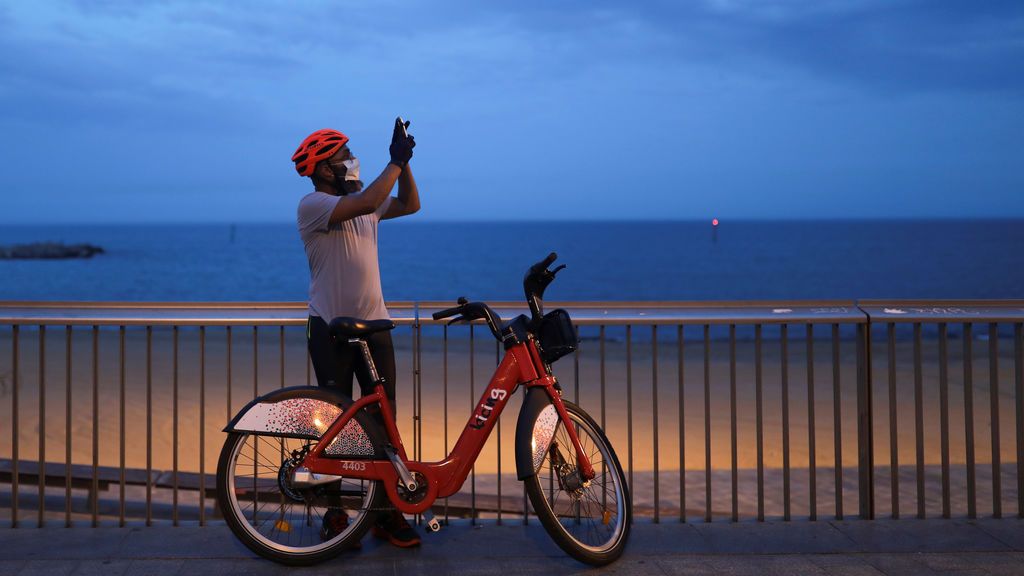 Un ciclista con mascarilla se para a tomar una foto