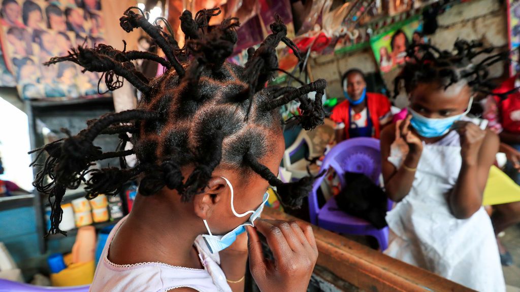 Una niña de Kibera, en Nairobi, se ajusta la mascarilla tras cambiar su look