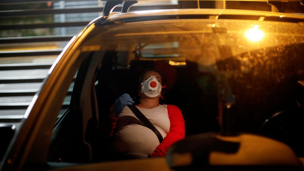 Mujer embarazada con mascarilla viajando en coche