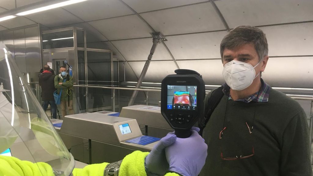 Un voluntario de la DYA toma la temperatura a un pasajero de metro bilbaíno.