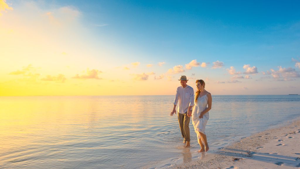 couple-walking-on-seashore-wearing-white-tops-during-sunset-1024989