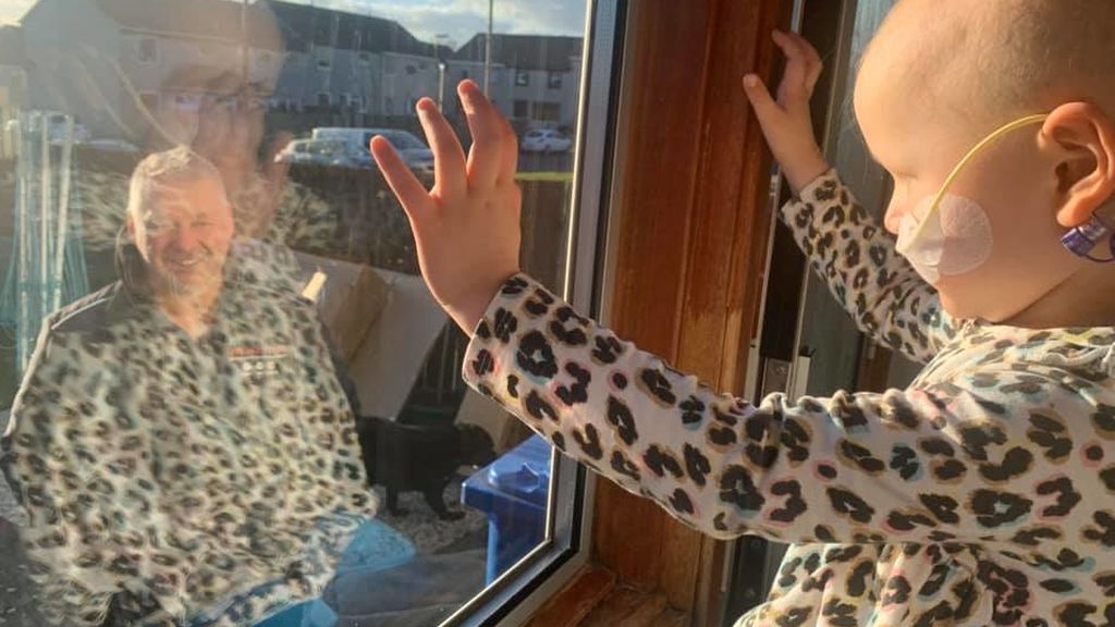 Mila habla con su padre desde la ventana de su casa