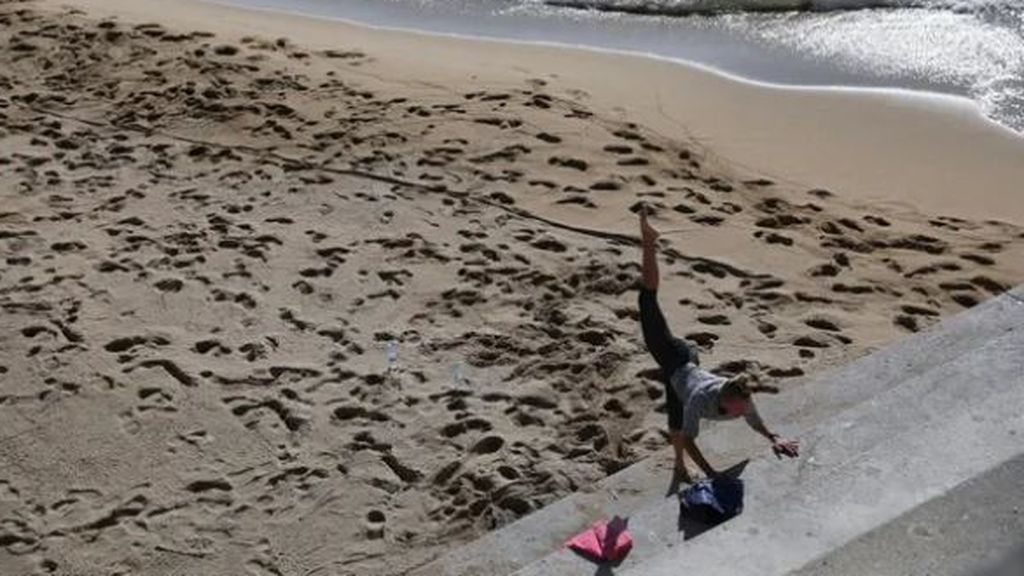 Una mujer hace ejercicios en una playa de Barcelona, una actividad autorizada en la fase 0