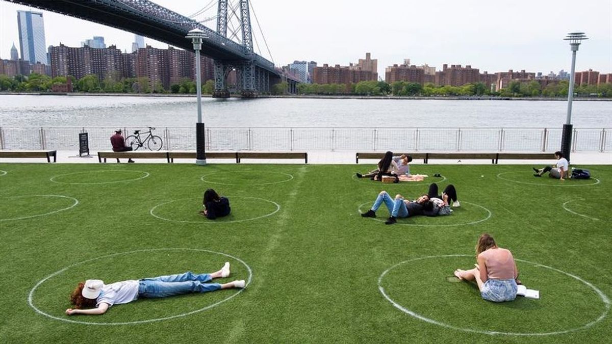 Jóvenes tumbados en un parque de Brooklyn, Nueva York, con la zonas marcadas sobre el césped para mantener la distancia social