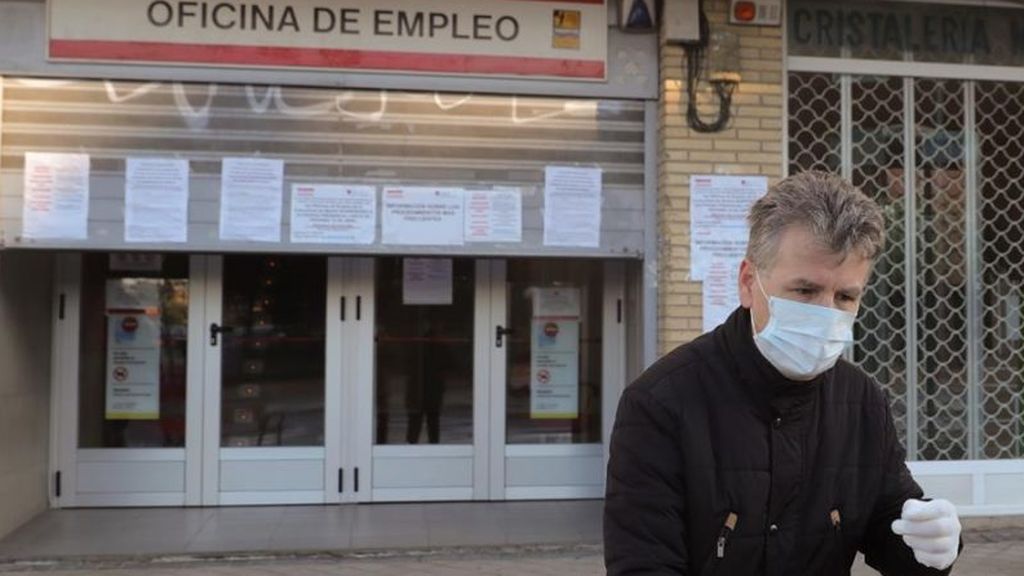 Un hombre junto a una oficina de empleo