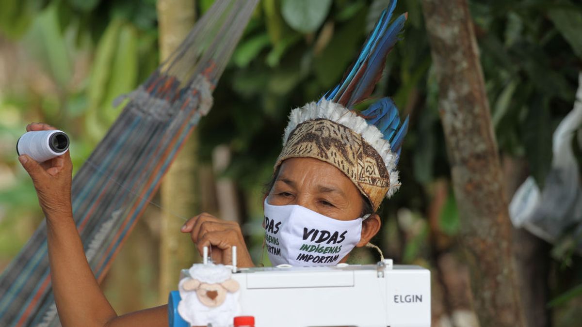 Una mujer indígena cose una mascarilla