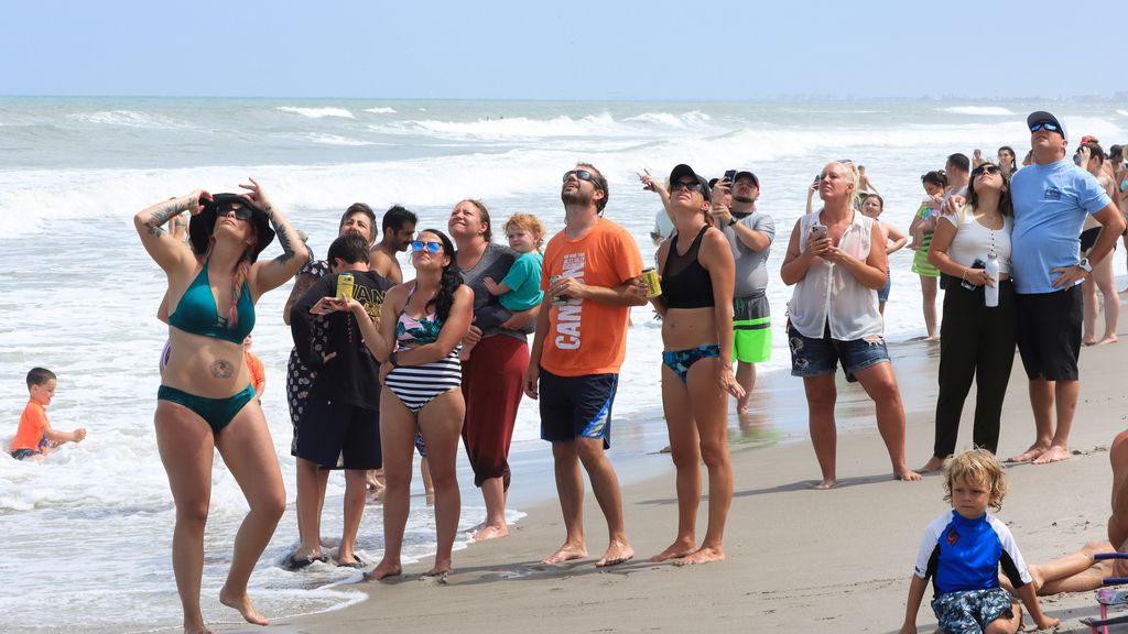 Una multitud observa desde la playa el lanzamiento exitoso de la Crew Dragon a la Estación Espacial Internacional