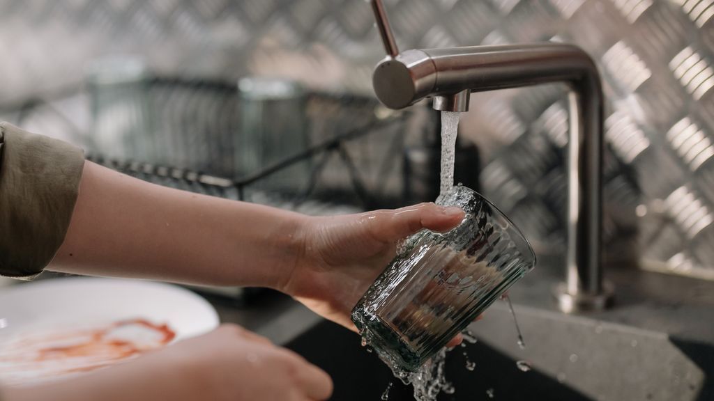 person-pouring-water-on-clear-drinking-glass-4108676