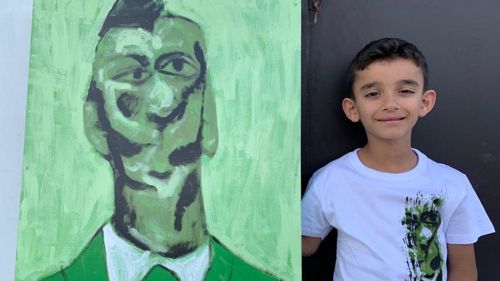 Hugo, con la obra que ha pintado y plasmado en camisetas