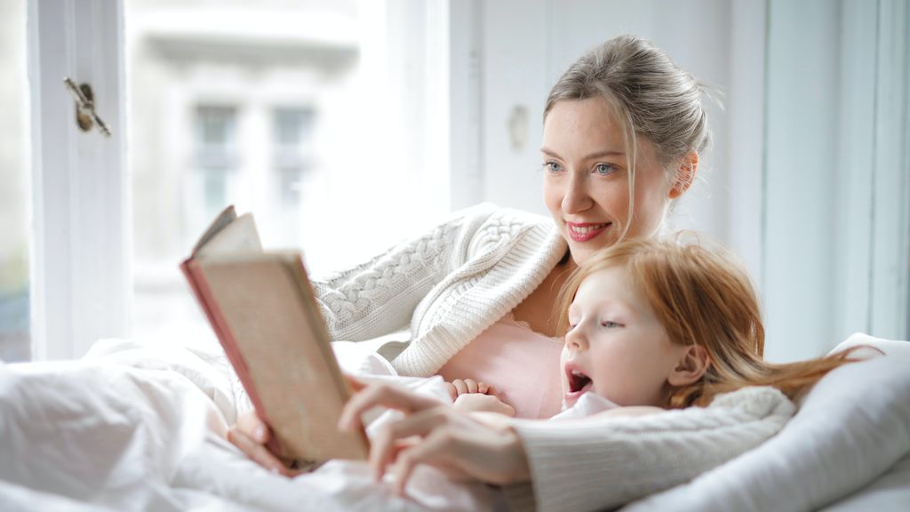 mother-and-daughter-reading-book-with-interest-in-bed-3755514