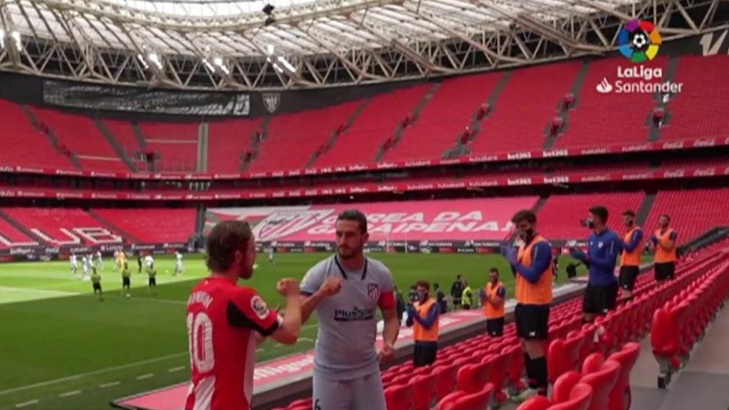 Koke y Muniain dejando un ramos de flores en la grada.