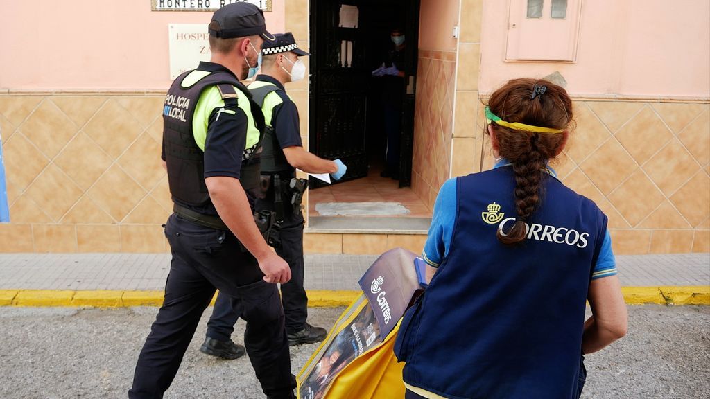 Una cartera entrega un burofax en el edificio aislado
