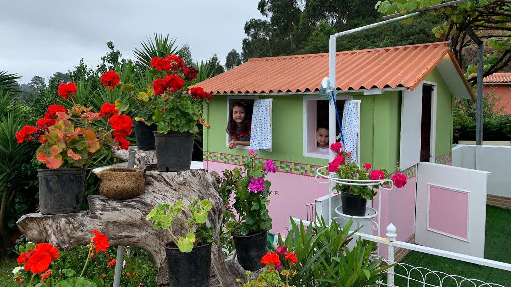 Judit y Miriam miran al exterior por las ventanas de la casita