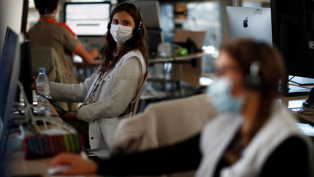 Trabajadores en oficina con mascarilla y medidas de distanciamiento