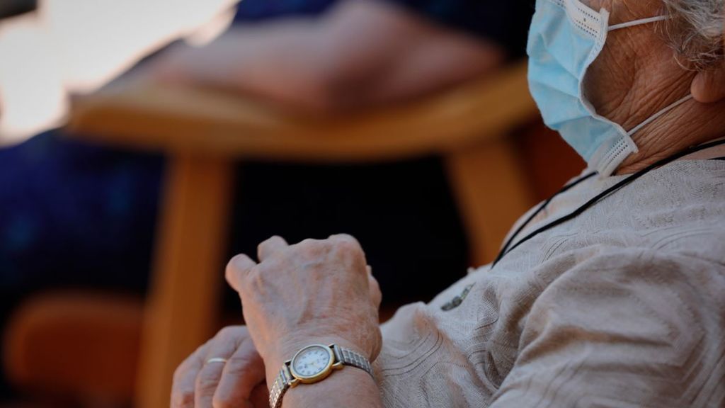 Una anciana esperando una visita en la residencia